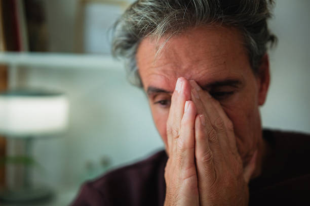istock Man experiencing stress, covering face with hands 2247543612