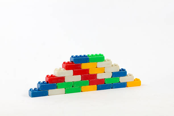 Used plastic blocks stairs in rainbow colors form a wall against a white background