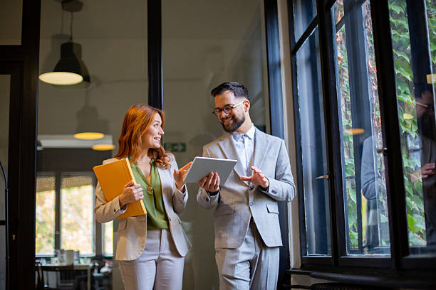 istock Business colleagues walking talking discussing data on tablet 2247546001