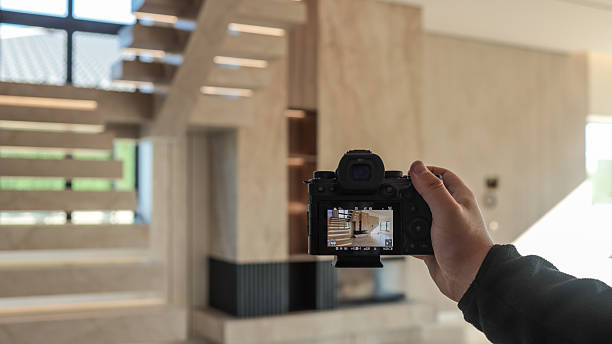istock Photographer capturing a modern interior with a staircase and fireplace 2247549350