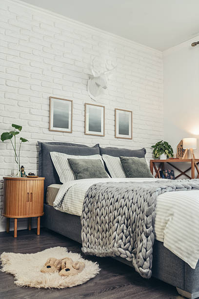 istock Stylish interior of bedroom with big comfortable grey bed 2247550746