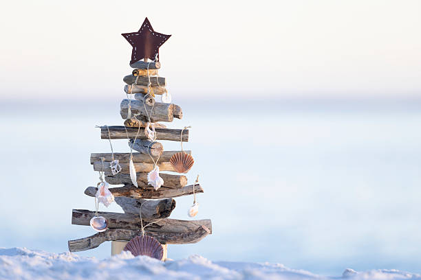 istock Driftwood Christmas tree on beach sea shell decorations 2247550761