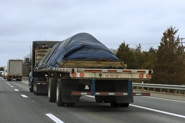 istock Trucker transports covered cargo on highway in cloudy weather 2247560559