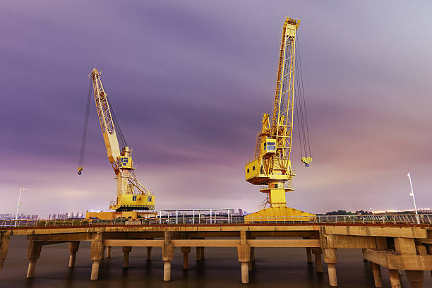 Commercial dock crane with dramatic sky and clouds at night