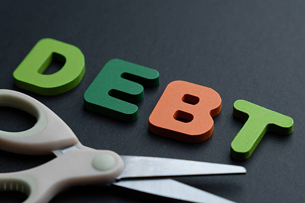 istock Letters spelling DEBT with a pair of scissors. 2247574702