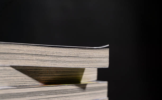 Minimal side view of a single book edge with subtle curvature and strong contrast, emphasizing paper texture and simplicity for study, learning, or literary themes.