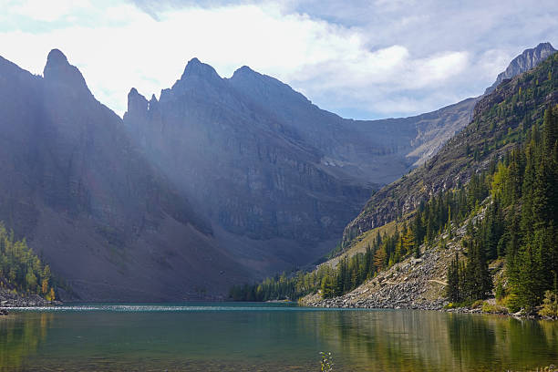 istock Turquoise lake nestled between wooded slopes and distant ridge 2247579507
