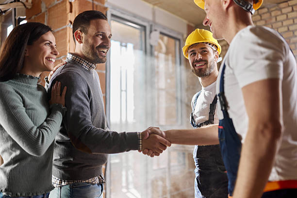 istock Happy manual workers came to an agreement with a couple at construction site. 2247581210