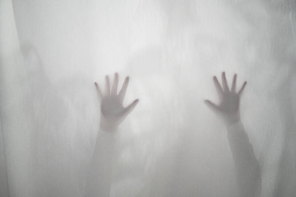 istock Diffuse view of two raised arms behind a semi-transparent curtain 2247590160