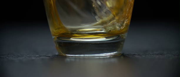 istock Golden beer with foamy head in glass on dark surface 2247591929