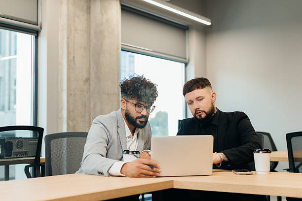 istock Businessmen collaborating on a laptop during office meeting 2247592572
