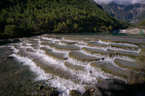 Lijiang, China - October 14th, 2025: The scenic view of Blue Moon Valley with fan-shaped stairs of water flowing.