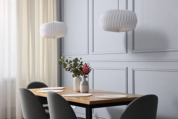 istock Soft chairs, table and vases with plants in stylish dining room 2247595826