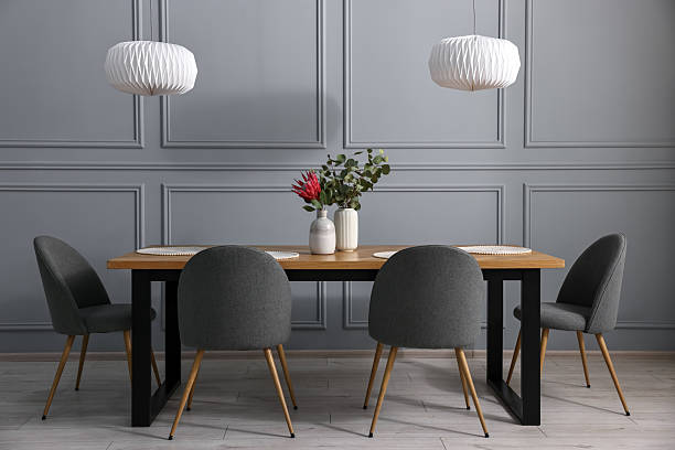 istock Soft chairs, table and vases with plants in stylish dining room 2247595872