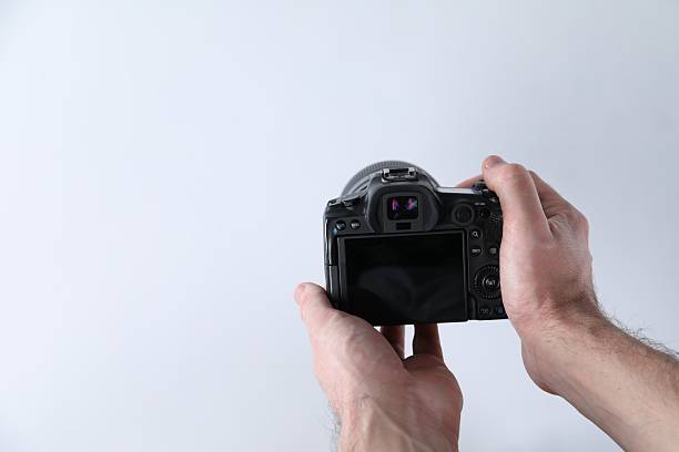 istock Photographer with professional camera on white background, closeup. Space for text 2247596434