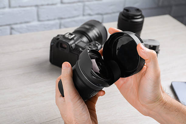 istock Photographer with camera lens at wooden table, closeup 2247596453