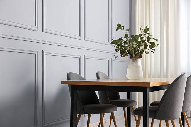 istock Soft chairs, table and vase with eucalyptus branches in stylish dining room. Space for text 2247596482