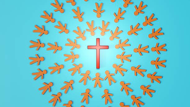 istock A Christian cross is surrounded by human figures arranged in a circle. 2247598623