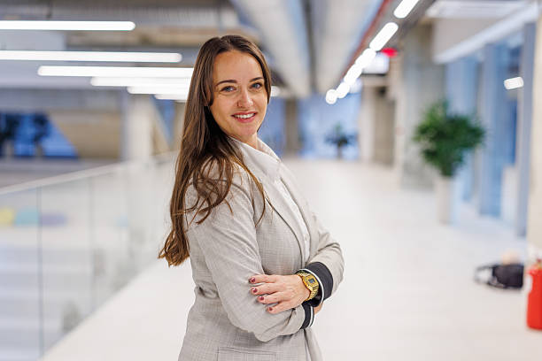 istock Confident businesswoman smiling posing in modern office hallway 2247601540