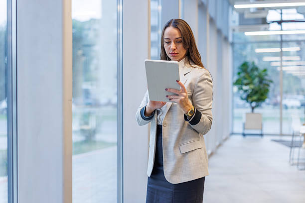 istock Businesswoman using digital tablet standing in modern office 2247601622