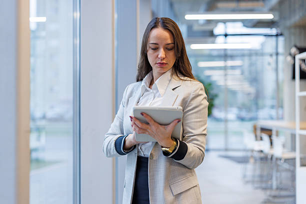 istock Businesswoman using digital tablet standing in modern office 2247601788