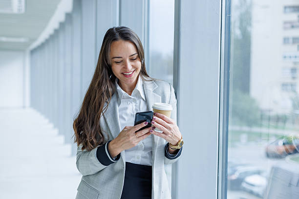 istock Businesswoman checking phone during coffee break in office 2247601795