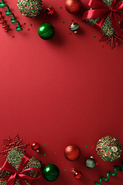 istock Christmas composition. Glittery gift boxes with red satin ribbons, shiny red and green ornaments, red snowflakes, and green curly ribbons on rich red background. 2247608956