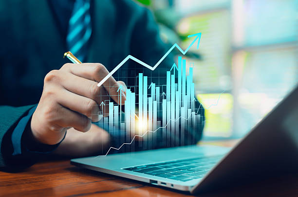 istock A professional analyzing virtual financial charts above a laptop, symbolizing business growth, data analytics, performance tracking, and strategic decision-making in modern digital environments. 2247610482