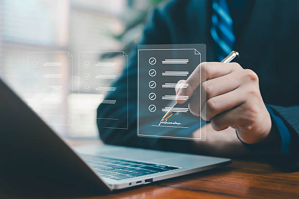 istock A businessman signing a virtual checklist document above a laptop, symbolizing digital approval, online verification, workflow management, and secure electronic documentation in modern workplaces. 2247610664