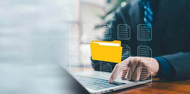 istock A business professional accessing a digital yellow folder on a laptop, representing file management, cloud storage, document organization, secure data access, and modern digital workflow solutions. 2247610713