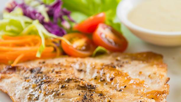 istock Delicious grilled fish with fresh salad and dressing 2247611433