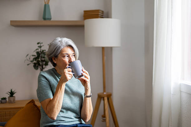 istock Senior woman relaxing at home drinking hot beverage 2247611441