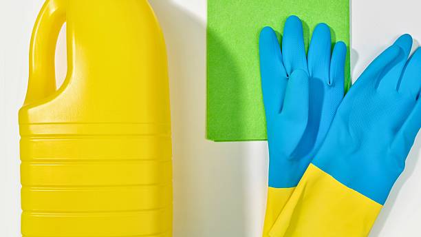 istock Bright yellow cleaning bottle blue gloves and green sponge on white background 2247615280