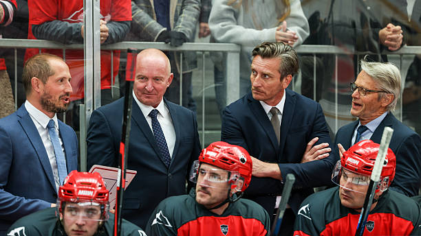 istock Ice Hockey Coaching Staff Engaged in Strategic Discussion on Bench 2247616005