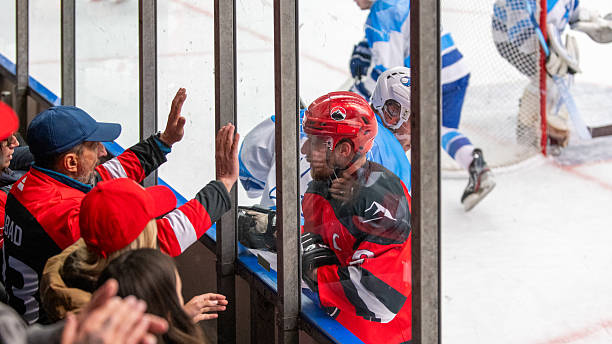 istock Ice Hockey Player Engaging with Fans Through Plexiglass Barrier 2247616091