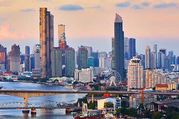 istock Modern city skyline at sunset with river and bridge 2247616819