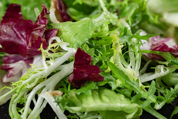 istock Fresh mixed salad field greens piled close up view 2247617112