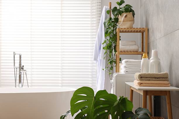 istock Stack of clean towels, plants, bathtub and deterrents in bathroom 2247621510