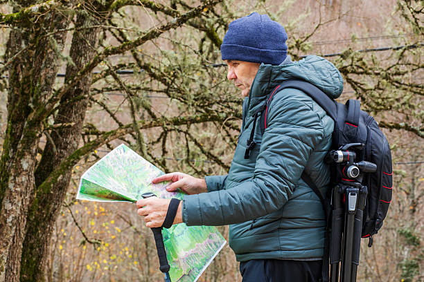 istock Exploring nature with a map in hand, a hiker pauses in a quiet forest trail while analyzing the lush surroundings during a chilly autumn afternoon 2247623031
