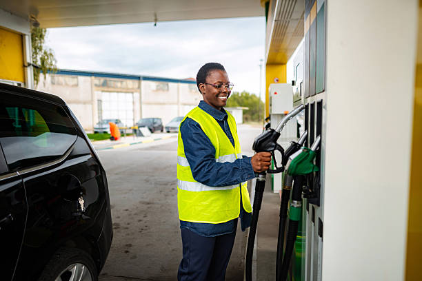 istock Woman worker smiling while refueling car at gas station 2247624607