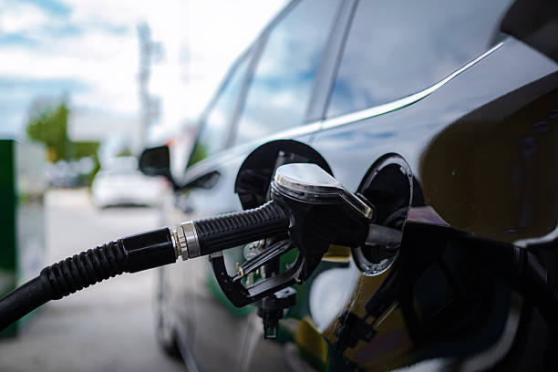 istock Fuel pump nozzle refilling a car with petrol at a service station 2247624627