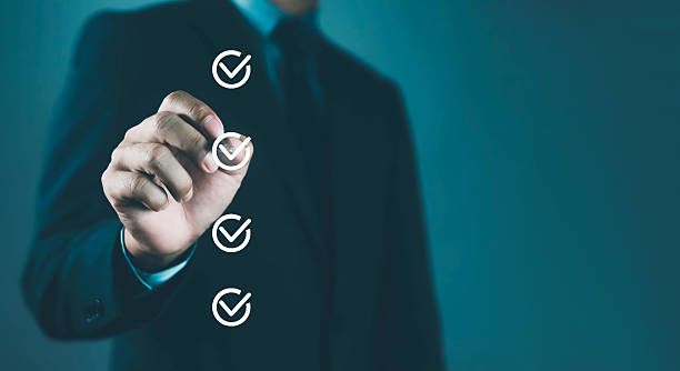 istock Businessman in suit marking checklist icons on virtual screen, representing task management, business planning, productivity strategy, project success, and goal achievement in professional workflow. 2247625197