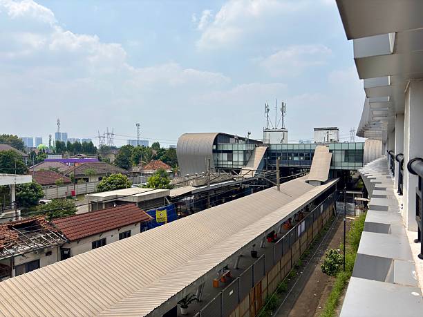 istock panoramic shot of a long railway station platform with a distinctive modern building and nearby residential rooftops. 2247625287