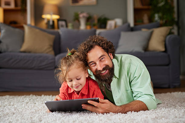 istock Father daughter bonding with tablet at home 2247626082
