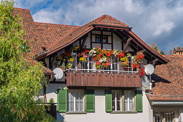 Bern, Switzerland - October 24, 2025: Typical Swiss house with a wooden balcony and lots of blooming flowers