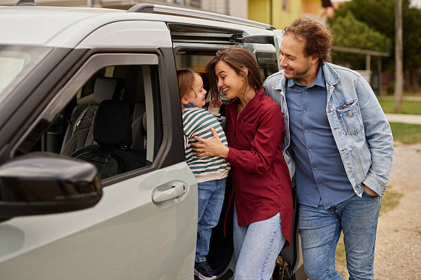 istock Happy family loading child into car for road trip 2247627526