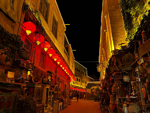 The alley is hung with red lanterns at night and old items are lined up in a row