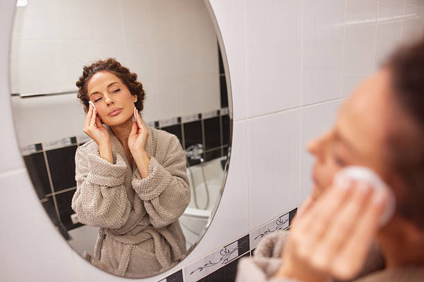 istock Woman removing makeup with cotton pad in bathroom 2247629097