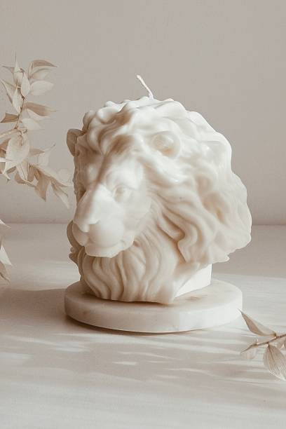 istock Elegant white lion-shaped candle Christmas decoration arranged on a table with flowers 2247630367