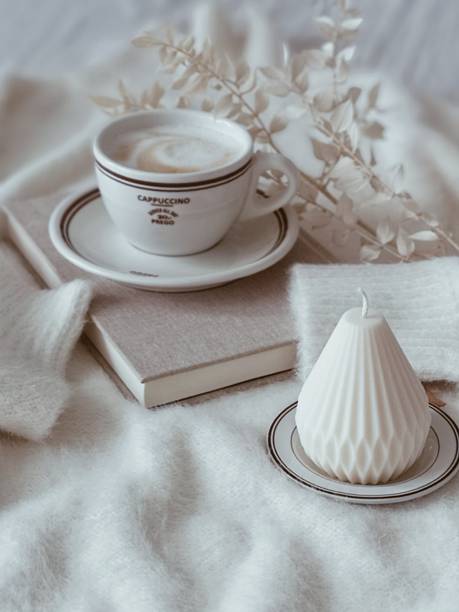Elegant table set at a cafe. Hot chocolate in a cup with white candles and decorations on the table